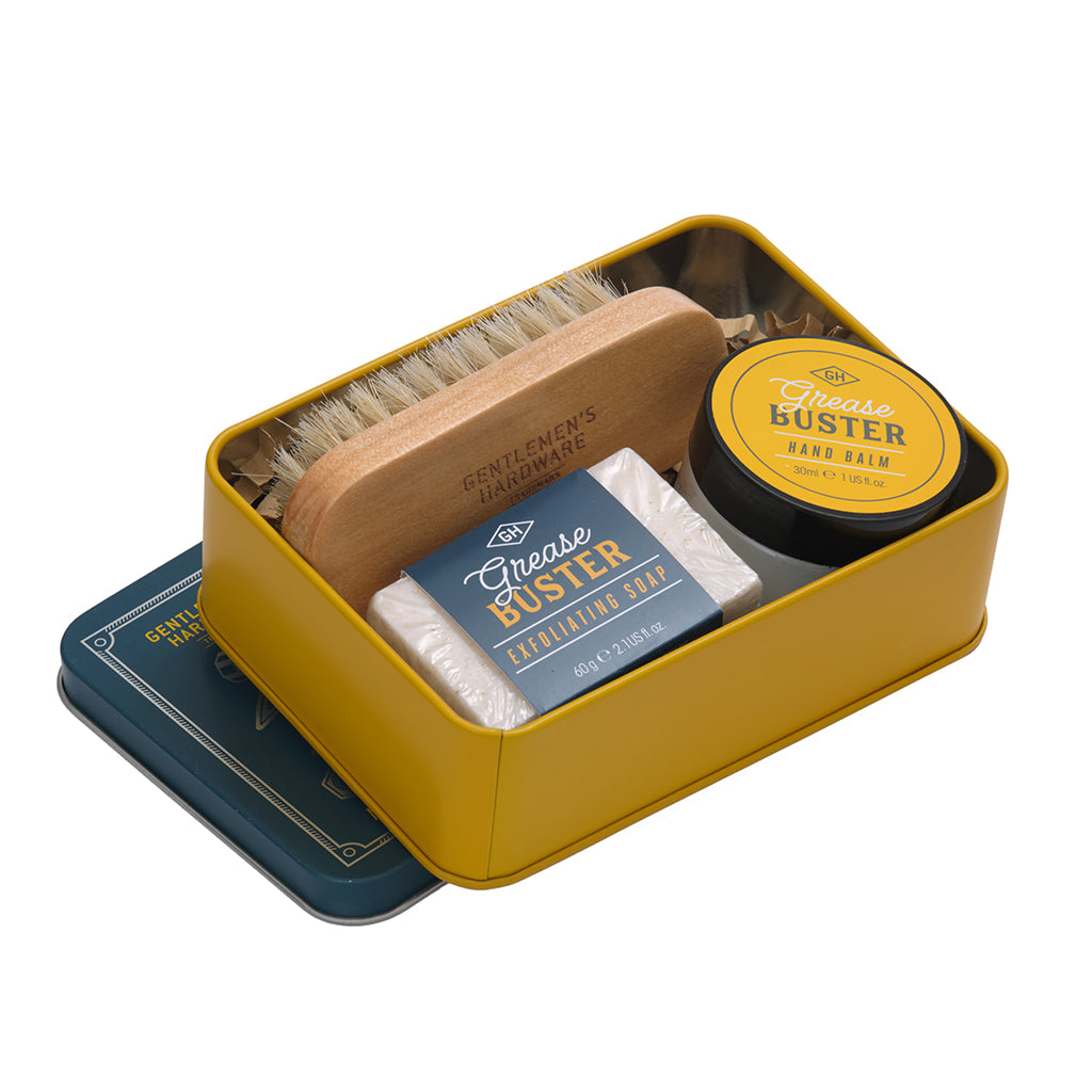Set of grooming products including a brush, soap, and balm in a yellow tin on a white background.