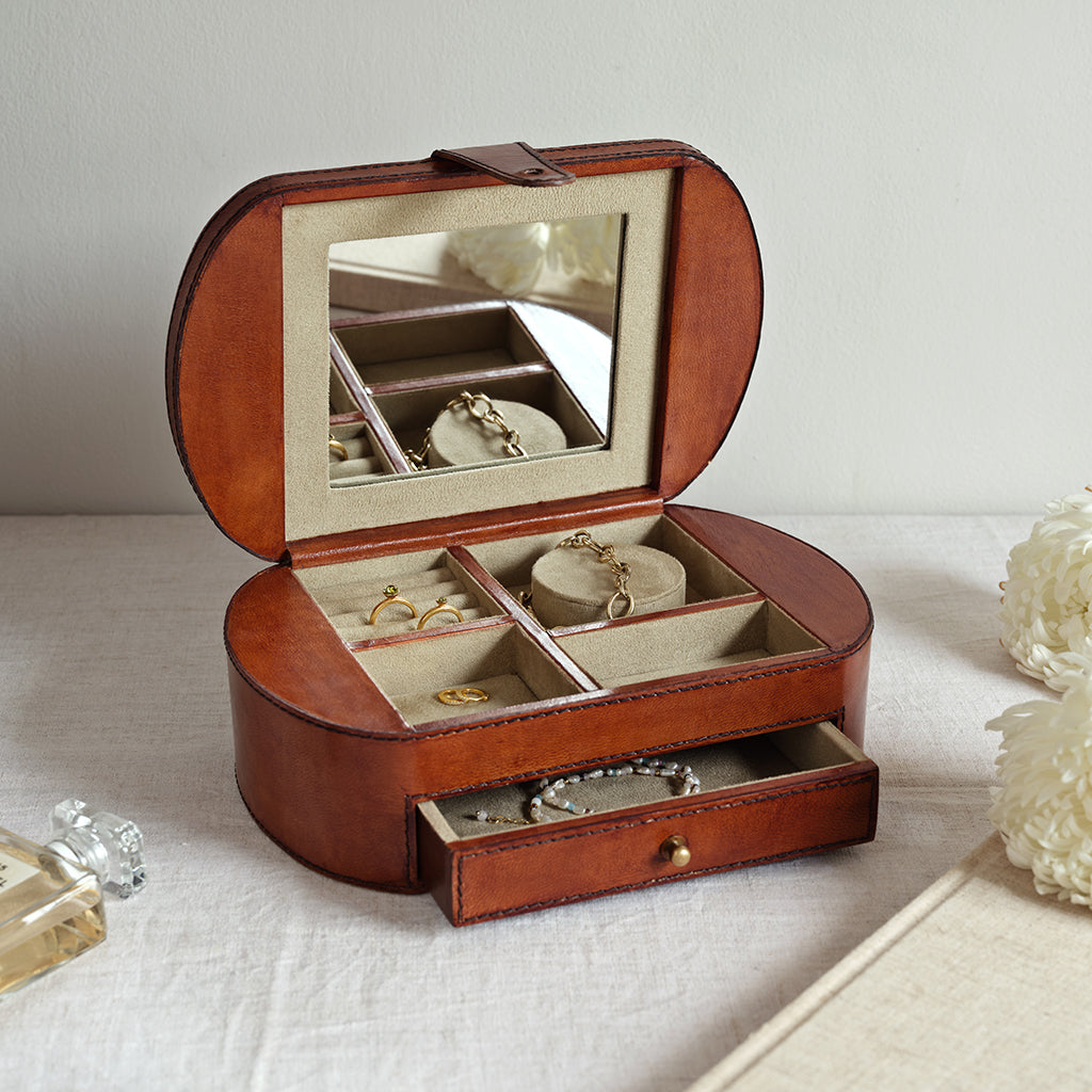 Open jewellery box with mirror lid on a light surface
