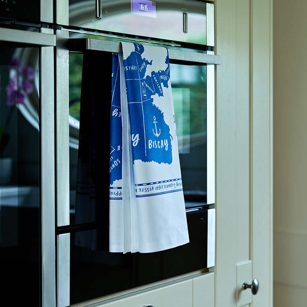 Shipping Forecast Tea Towel hanging on an oven door in a kitchen.