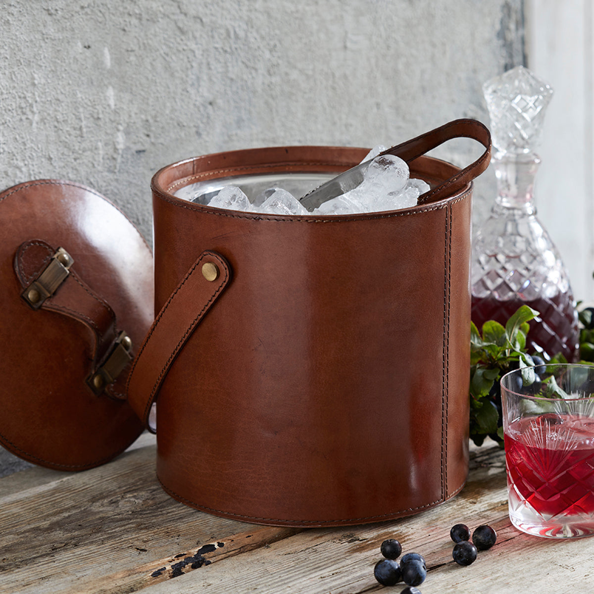 Leather ice bucket with lid off and leather handled tongs perfect for the bar cart
