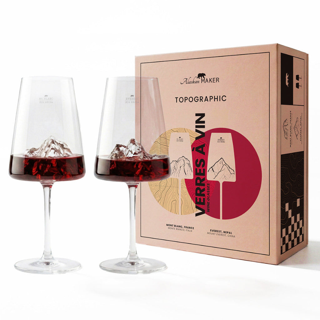 Two wine glasses with red wine and ice cubes next to a cardboard packaging box for wine glasses.