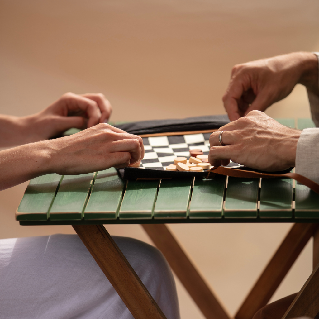 Waxed canvas travel chess being played by couple close up