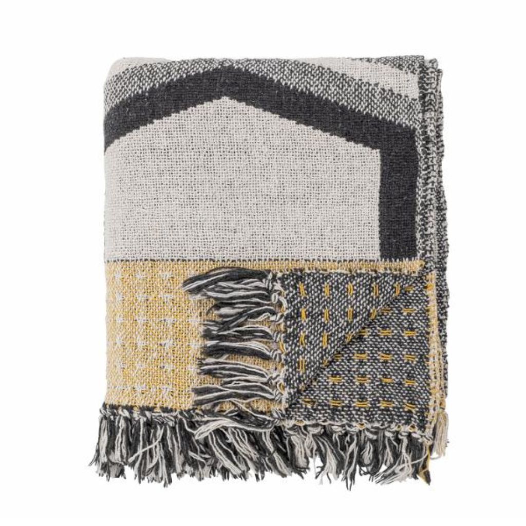 Woven blanket with geometric pattern and fringes on a white background