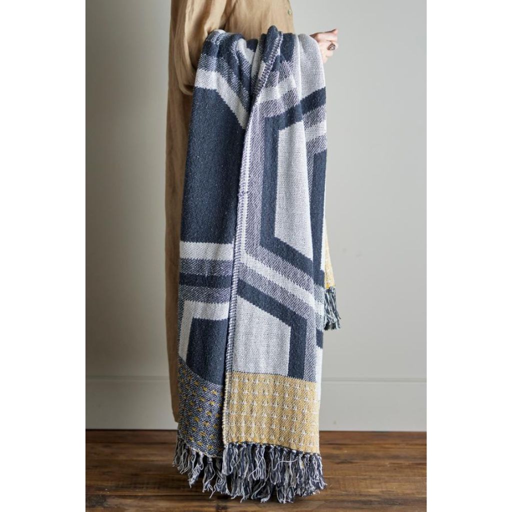 Person holding a patterned blanket with geometric design