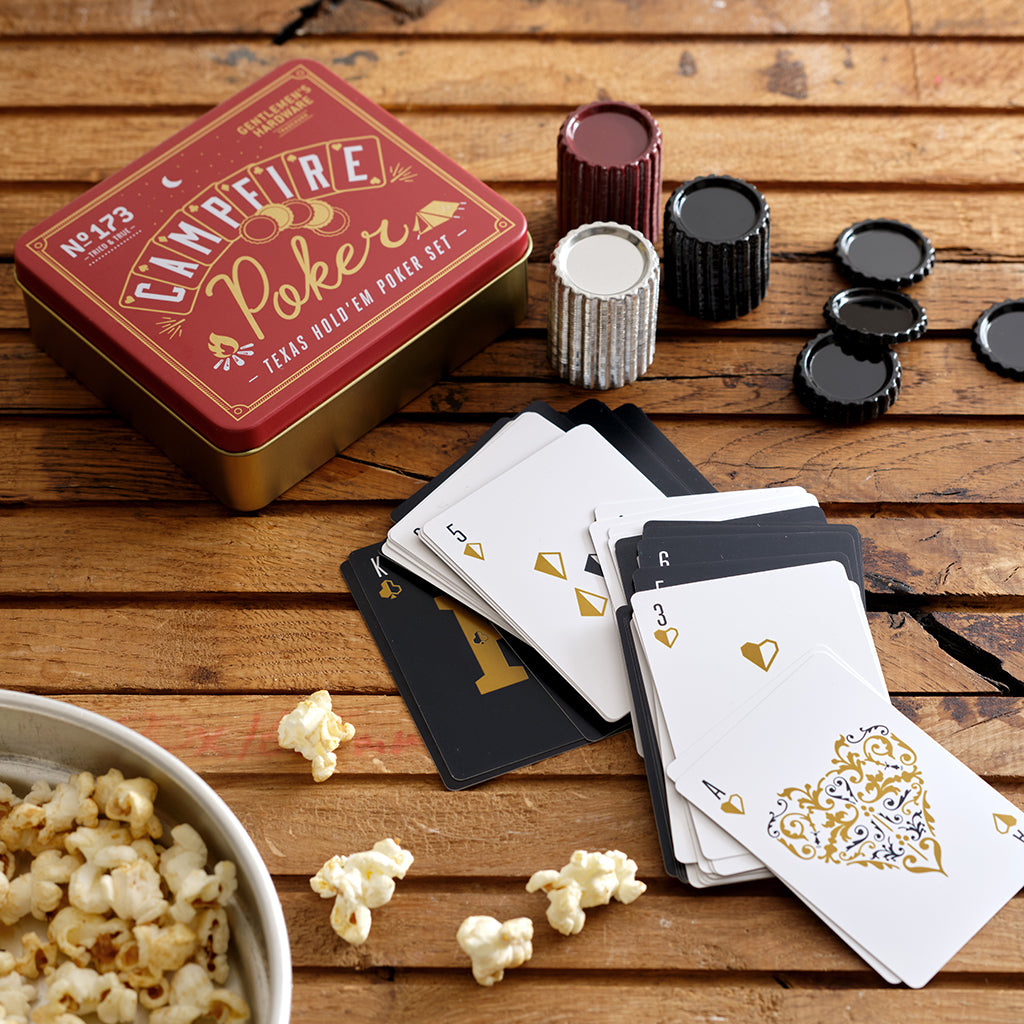 Campfire poker set with cards, chips, and popcorn on a wooden surface
