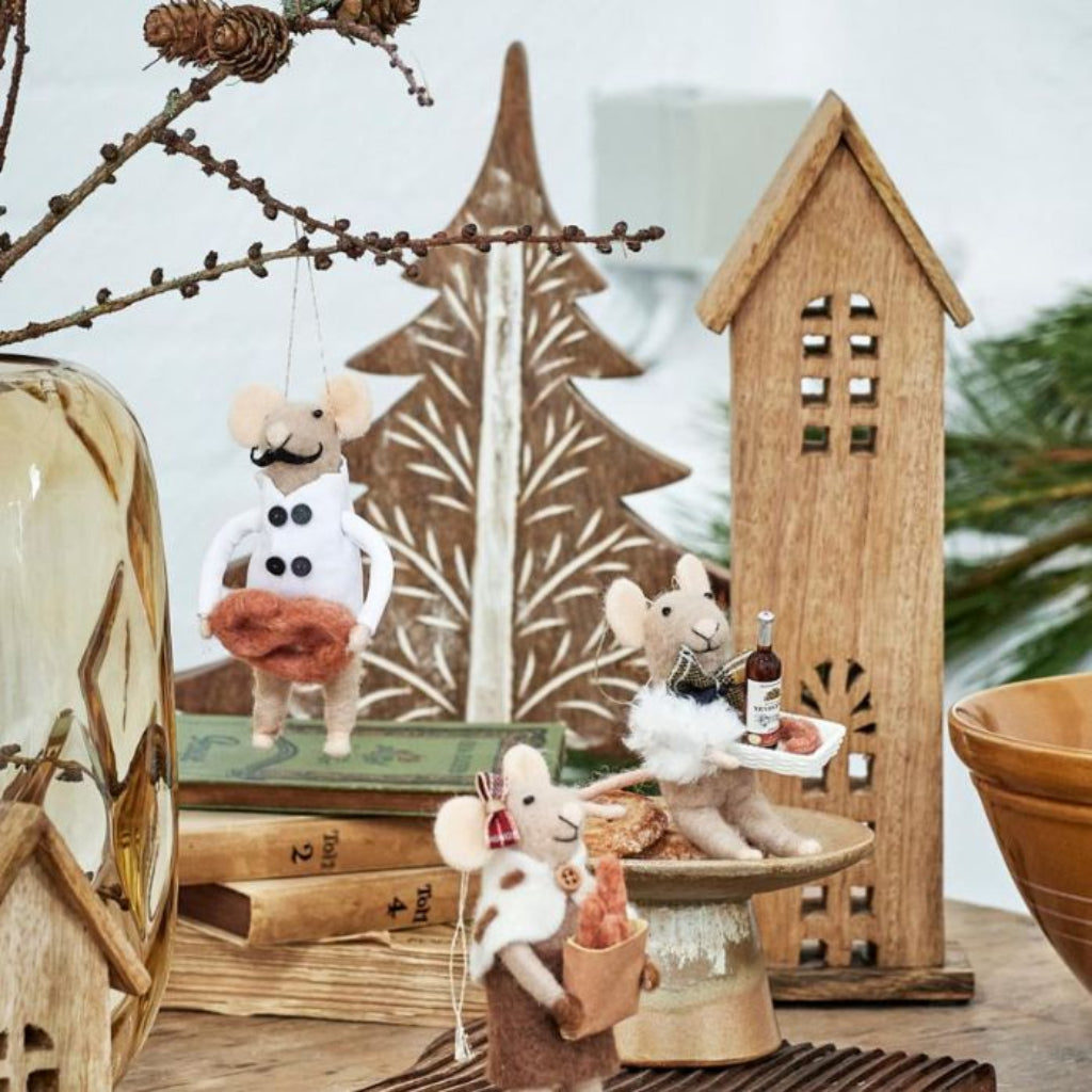 Decorative scene with small animal figurines, wooden houses, and a lantern.