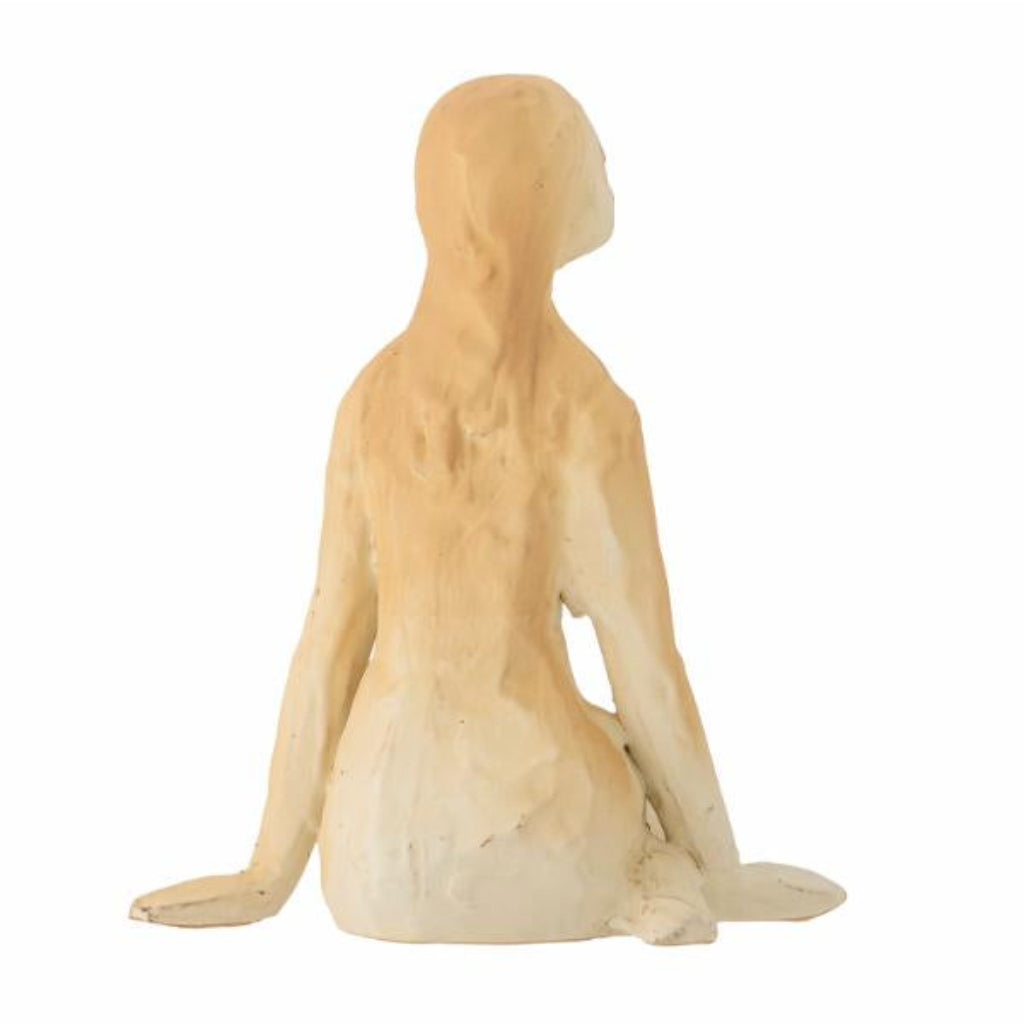 Sculpture of a nude figure sitting on a white background