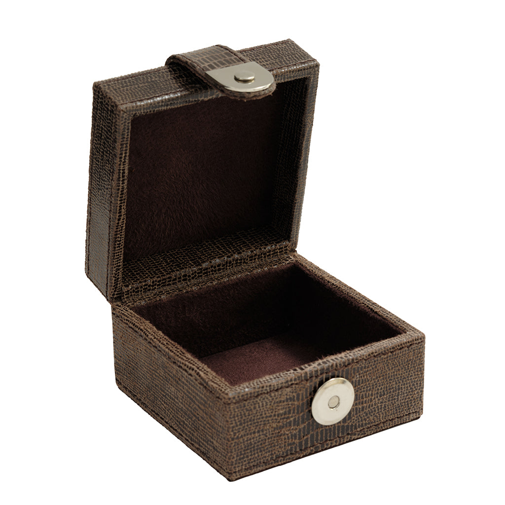 A small open jewelry box with a textured dark brown exterior and a dark brown velvet-lined interior, featuring a silver-tone snap closure on the lid and a round snap button on the front.