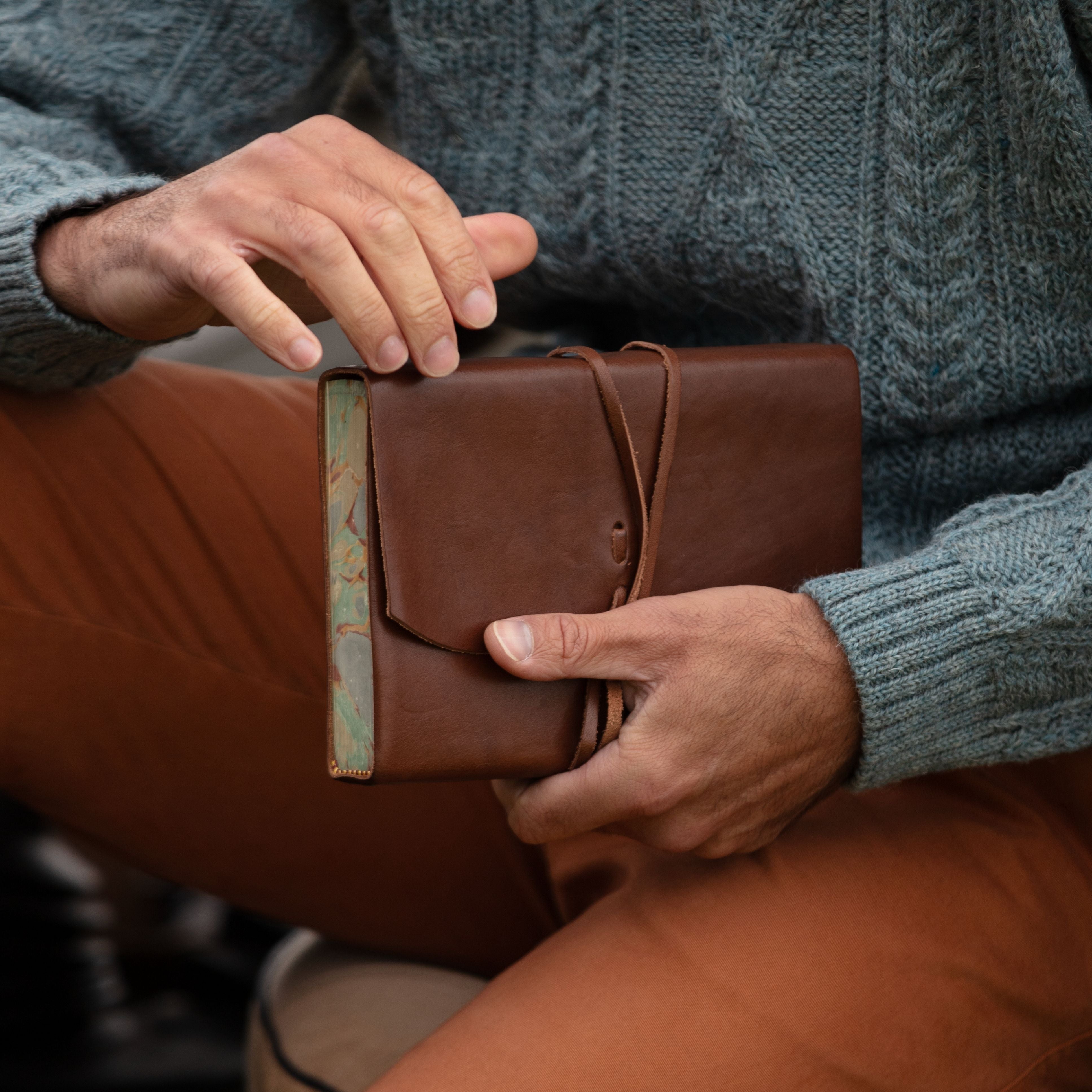 Leather journal with Marble Edge close up being held by man