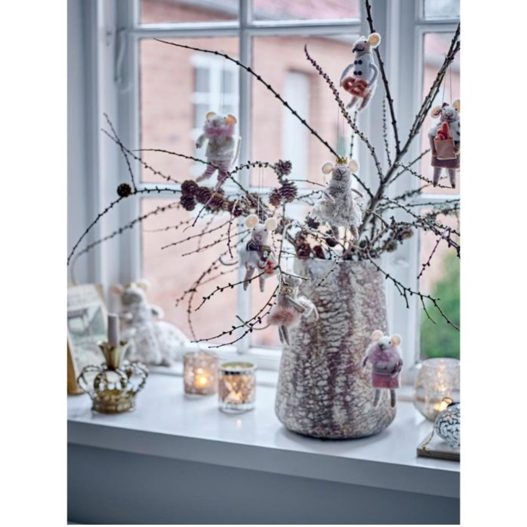 Decorative arrangement with a vase, branches, and small figurines on a windowsill.