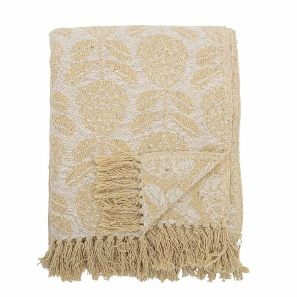 Yellow and white patterned throw blanket with fringes on a white background
