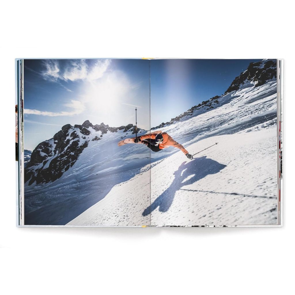 Person skiing down a snowy mountain with a clear blue sky