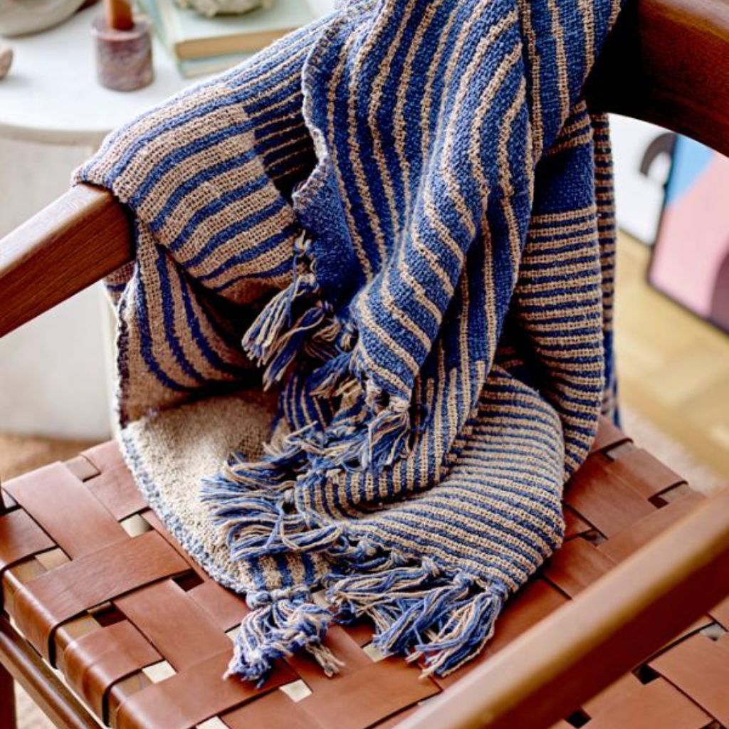 Blue and beige striped blanket draped over a wooden chair