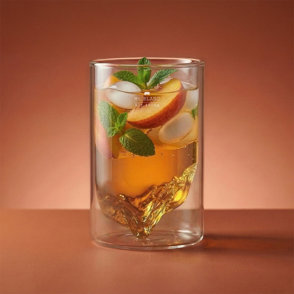 Glass of iced tea with peach slices and mint leaves on a brown background